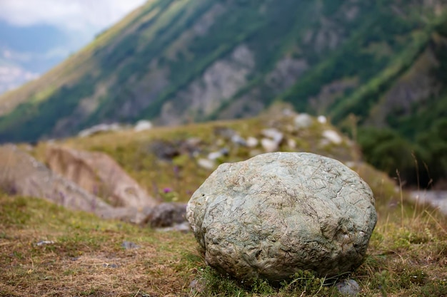 Heavy stone against the backdrop of mountains Tourism and travel in the mountains