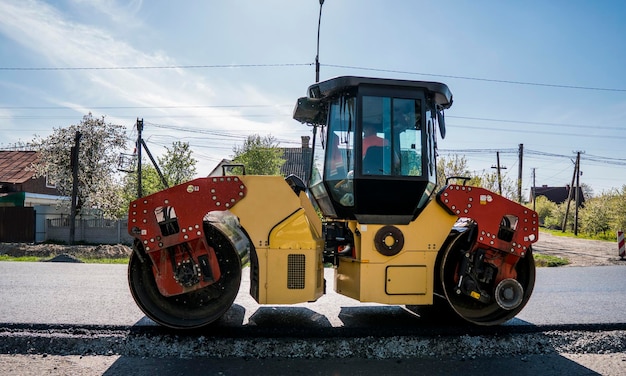 写真 新しい道路建設現場で作業しているアスファルト舗装での重い振動ローラーの修理