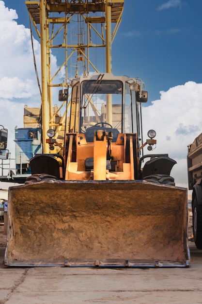 Heavy wheel loader with a bucket at a construction site Equipment for earthworks transportation and loading of bulk materials earth sand crushed stone