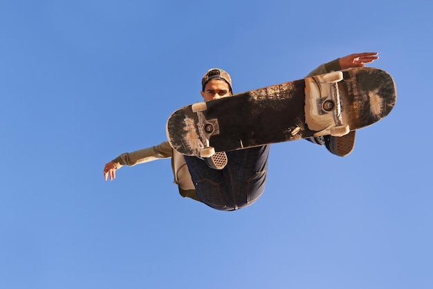 Foto heb je de vaardigheden van deze gezien? een jonge man die trucjes doet op zijn skateboard in het skatepark?