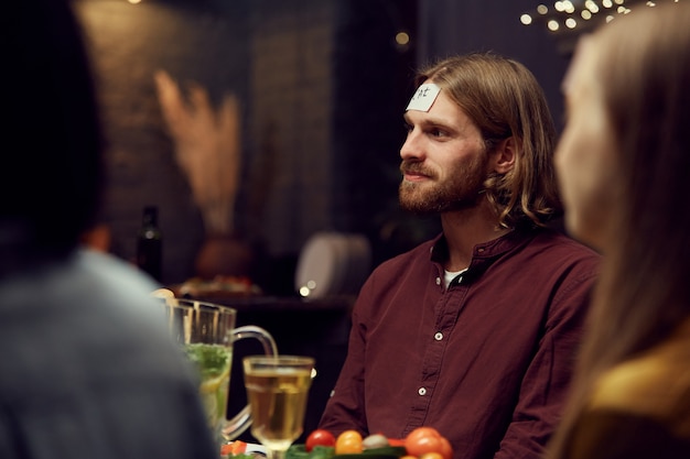 Foto hedendaagse man raden raadspel op feestje