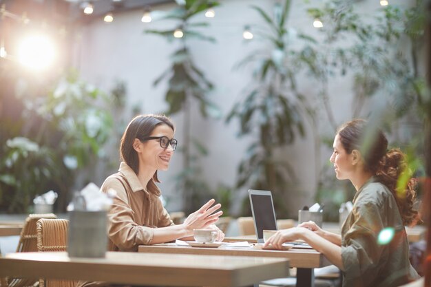 Hedendaagse vrouwen genieten van lunch in Cafe