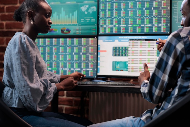 Hedge fund trading company employees discussing about possible market crash while analyzing real time data. Financial company brokers in office, trying to predict buy and sell price ranges.