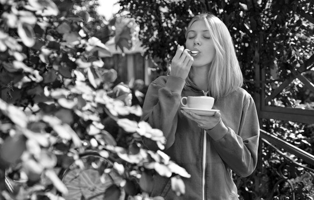 Гедонизм и гурман наслаждаются вкусным сливочным капучино в цветущем саду девушка пьет капучино для гурманов