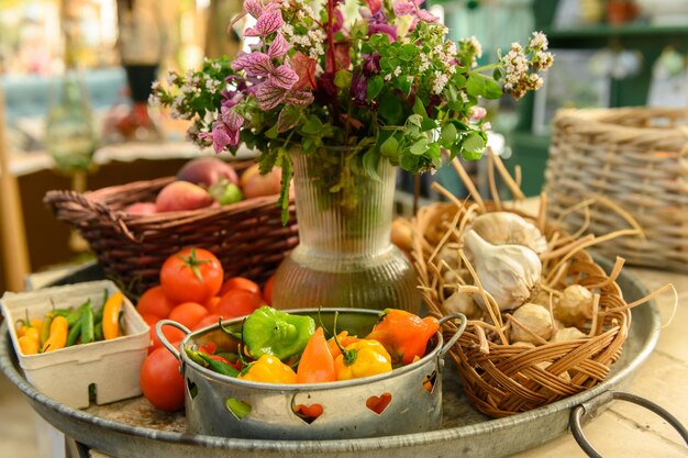 Heel rustieke verkoopkraam met tomaten, appels, paprika's en bloemen.