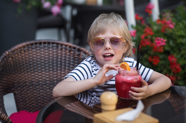 Heel schattig jongetje in het café drinken van verse limonade.