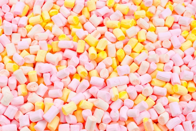 Heemst. achtergrond van roze en gele kleurrijke mini marshmallows.