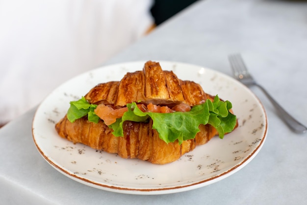 Heerlijk en gezond ontbijtcroissant met zalmsla en roomkaas op een bord