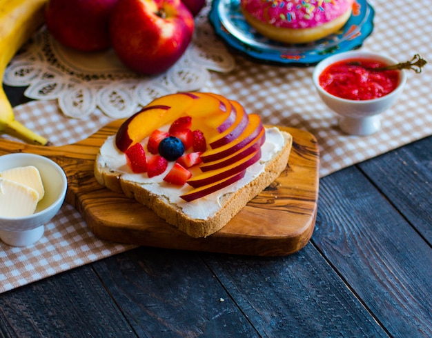 Heerlijk gezond ontbijt, fruitsandwiches met verschillende vullingen, kaas, banaan, aardbei, vis, boter, bosbes