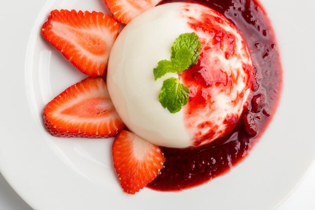 Heerlijk Italiaans dessert Panna Cotta met aardbei, munt en bessen saus in een plaat