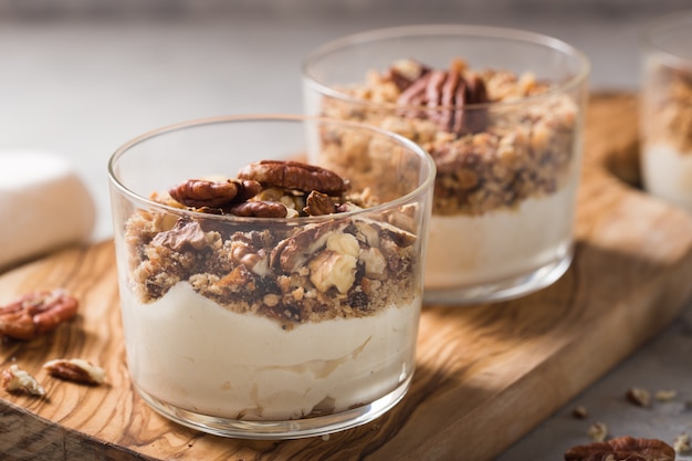 Heerlijk natuurlijk yoghurtparfait met karamel, pecannootnoten op conctere achtergrond