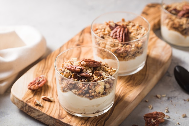 Heerlijk natuurlijk yoghurtparfait met karamel, pecannootnoten op conctere achtergrond