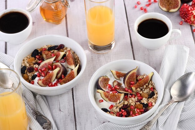 Heerlijk ontbijt havermout muesli met griekse yoghurt verse vijgen gedroogd fruit en granaatappel