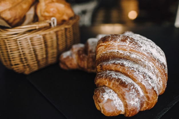 Heerlijk ontbijt met verse croissants op een zwarte achtergrond, heerlijke het exemplaarruimte van de baksel hoogste mening voor tekst