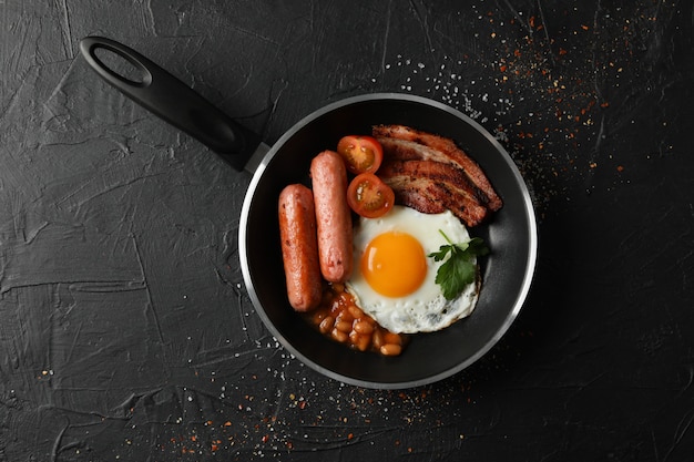 Heerlijk ontbijt of lunch met gebakken eieren op zwarte ondergrond, bovenaanzicht