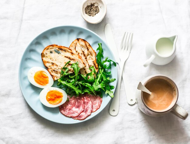 Heerlijk ontbijt of tussendoortje salami worst gekookt ei rucola gegrild brood en koffie