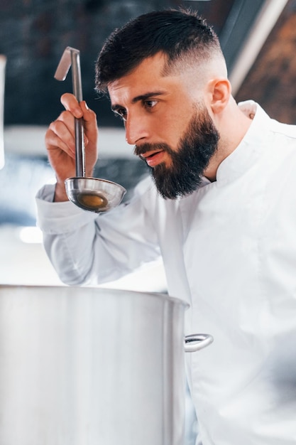 Heerlijk product maken Chef-kok in wit uniform kokend eten in de keuken Drukke dag op het werk