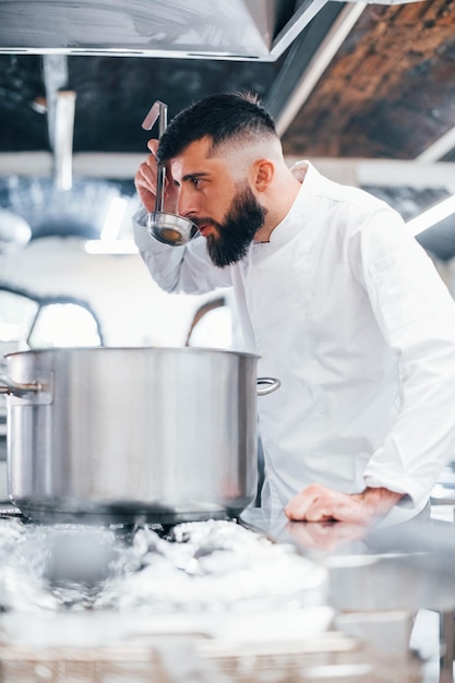 Heerlijk product maken Chef-kok in wit uniform kokend eten in de keuken Drukke dag op het werk