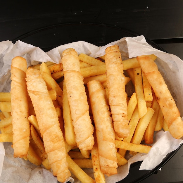 Heerlijk snackbord, frietjes, uienringen, loempia's of worstjes op tafel