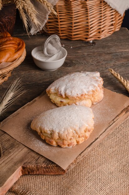 Heerlijk vers culinair gebak - zoete zandkoekjes gevuld in poedersuiker op houten achtergrond