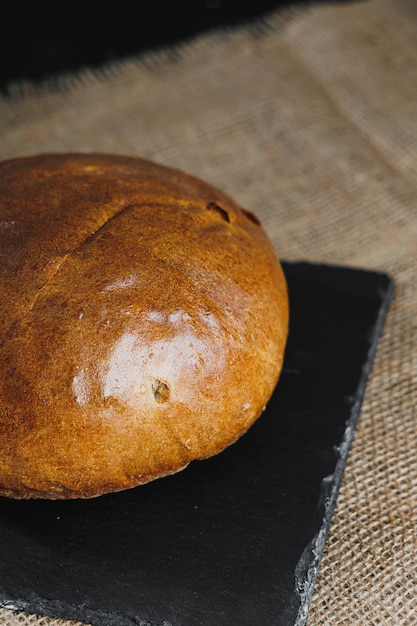 Heerlijk vers rond roggebrood op een donkere achtergrond Krokant vers brood Vers gebakken brood