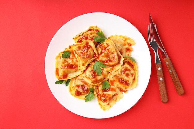 Heerlijk voedselconcept met ravioli op rode achtergrond