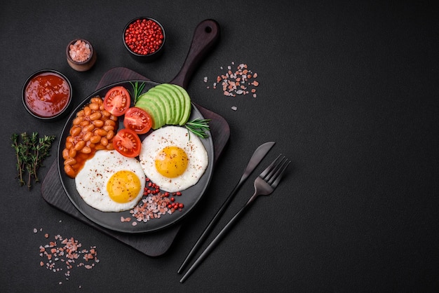 Heerlijk voedzaam Engels ontbijt met gebakken eieren, tomaten en avocado