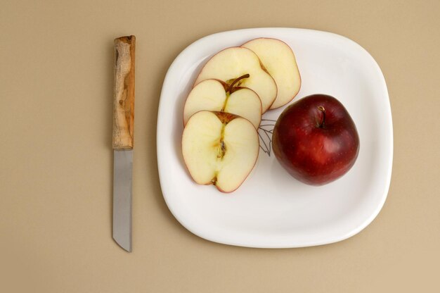 Foto heerlijke appel en plak op een wit bord met mes en vork.