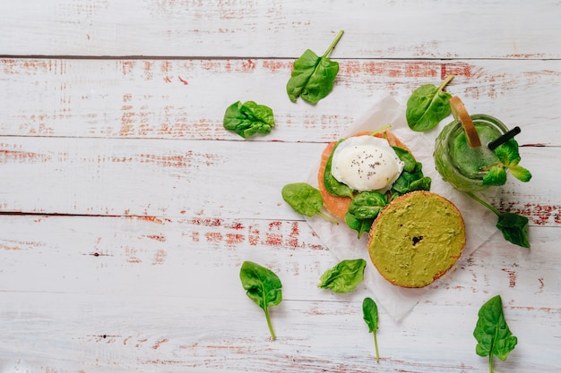 Heerlijke bagel met sesam- en chia-brood, van binnen bevat het zalm, gebakken ei en basilicum.