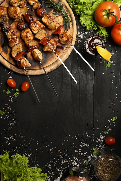 Heerlijke barbecuespiesjes met verse groenten op zwarte rustieke houten tafel