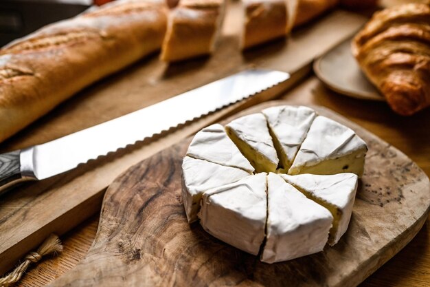 Heerlijke brie kaas met witte schimmel snijden voor een ontbijt op een keukentafel