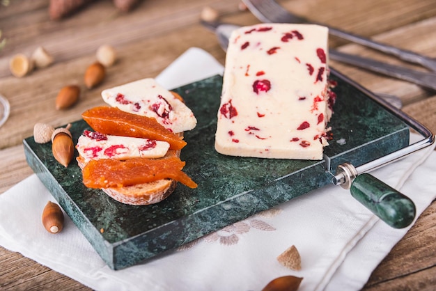 Heerlijke Britse Cheddar-kaas met cranberry op een marmeren kaassnijtafel