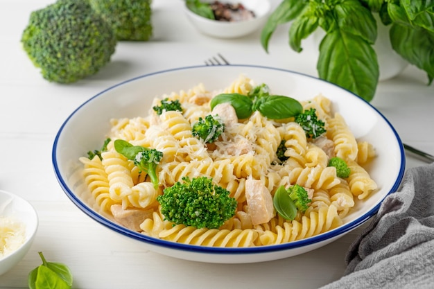 Foto heerlijke broccoli en kip fusilli pasta met parmesan kaas en verse basilicum gezond eten