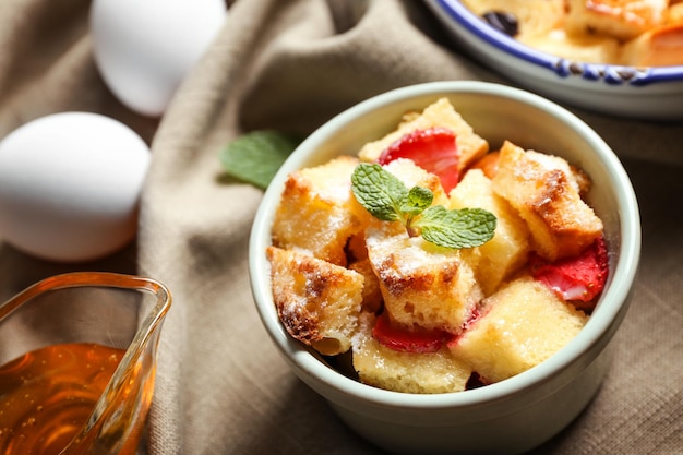 Heerlijke broodpudding met aardbei in kom op servet