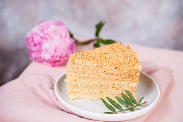 Heerlijke cake honing cake is op de tafel met bloemen.