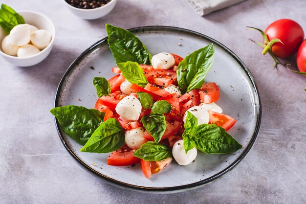 Heerlijke caprese salade met rijpe tomaten mozzarella kaas en basilicum op een bord