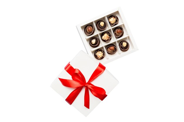 Heerlijke chocoladepralines in rode doos voor Valentijnsdag Hartvormige doos chocolaatjes bovenaanzicht geïsoleerd op witte achtergrond