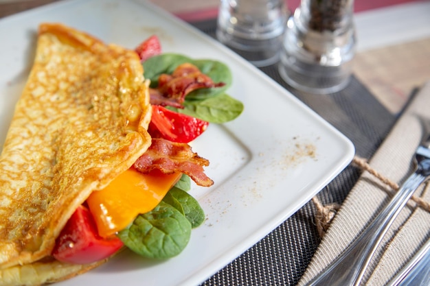 Heerlijke close-up omelet met kaas, grill tomaat.ham, krokante becon en salade.