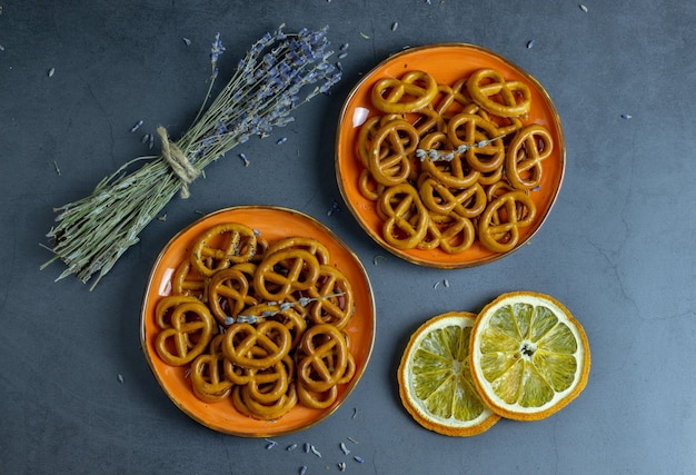 Foto heerlijke crackers, lavendel en sinaasappel op een concrete achtergrond.