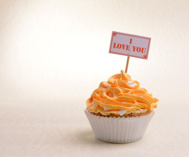 Foto heerlijke cupcake met inscriptie op tafel op beige