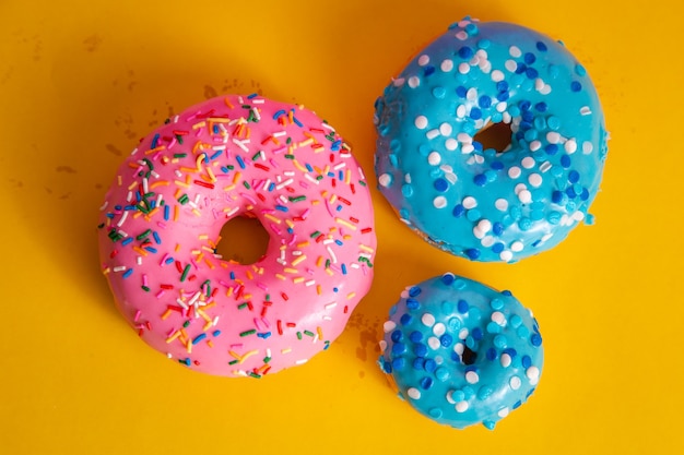 Heerlijke donuts die op gele achtergrond kleuren