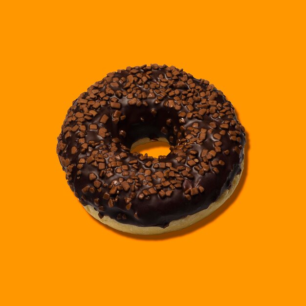 Heerlijke donuts met donkere chocolade geïsoleerd op oranje achtergrond