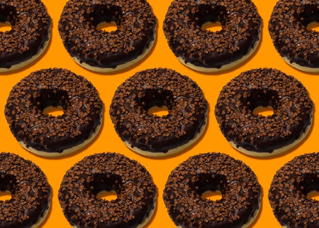 Heerlijke donuts met donkere chocolade geïsoleerd op oranje achtergrond