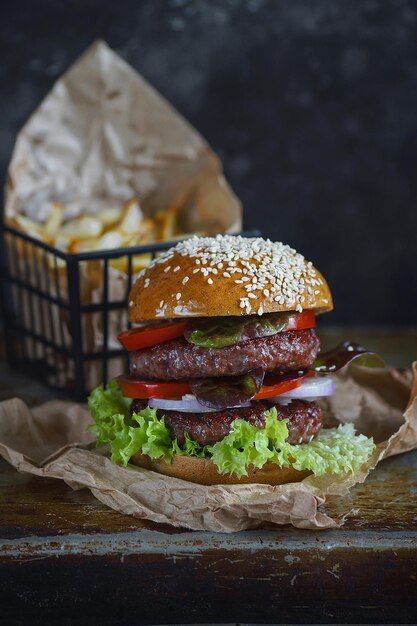 Heerlijke dubbele burger met frietjes op een donkere ondergrond, Sfeervol restaurant, Foodfotografie