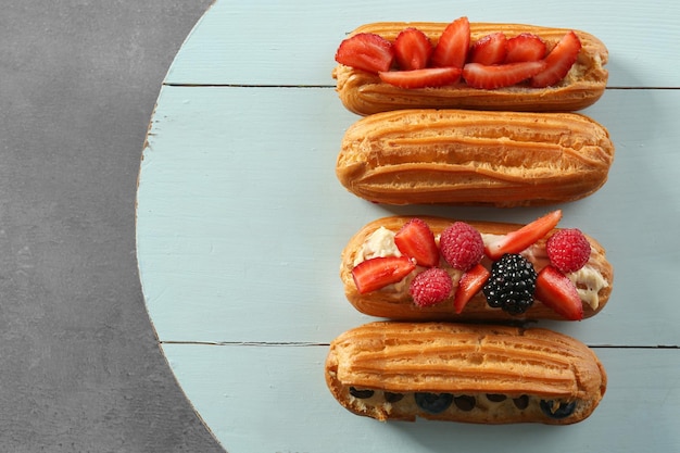 Heerlijke eclairs met bessen op houten dienblad