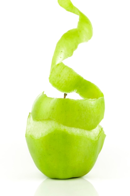 Foto heerlijke en verse groene appel schilt de schil om hem op een witte achtergrond te kunnen eten