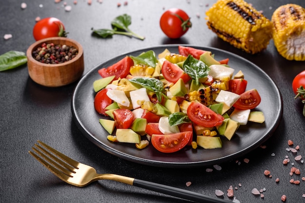 Heerlijke frisse salade met tomaten, avocado, kaas en gegrilde mais met olijfolie. mediterrane keuken