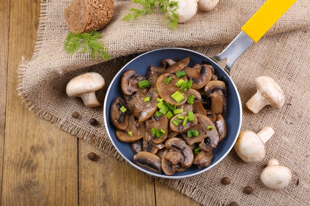 Heerlijke gebakken champignons in pan op tafel close-up