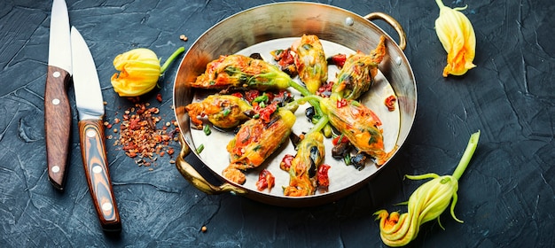 Heerlijke gebakken courgette bloemen gevuld met zongedroogde tomaten. Zomer eten.