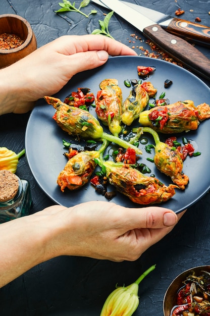 Heerlijke gebakken courgette bloemen gevuld met zongedroogde tomaten. Zomer eten.